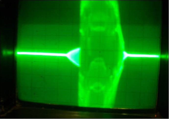 Oscillograph of the both transistors collector voltage in the physical model of the system (7) corresponding to the interaction process between two FPU recurrences corresponding to the interaction dynamics of the electron current Ielectron. and that of the phonon current Iphonon. Corresponds to prevailing of the electron current. The pulse has a complex intrinsic structure of the high frequency FPU recurrence (few GigaHertz). Vert axis 0.5 μ sec/cm, Horiz axis-2volts per cm.